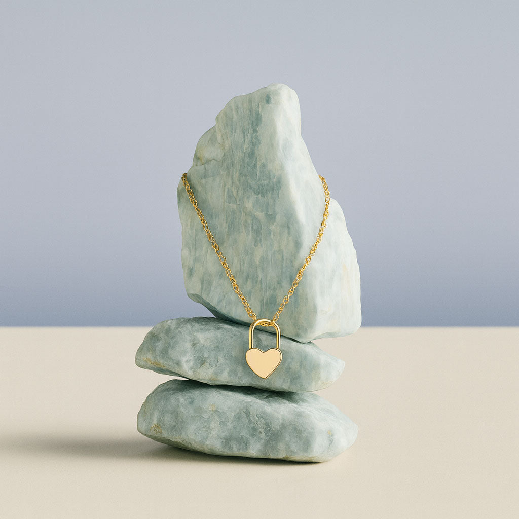 Gold necklace with a heart pendant on a stack of stones