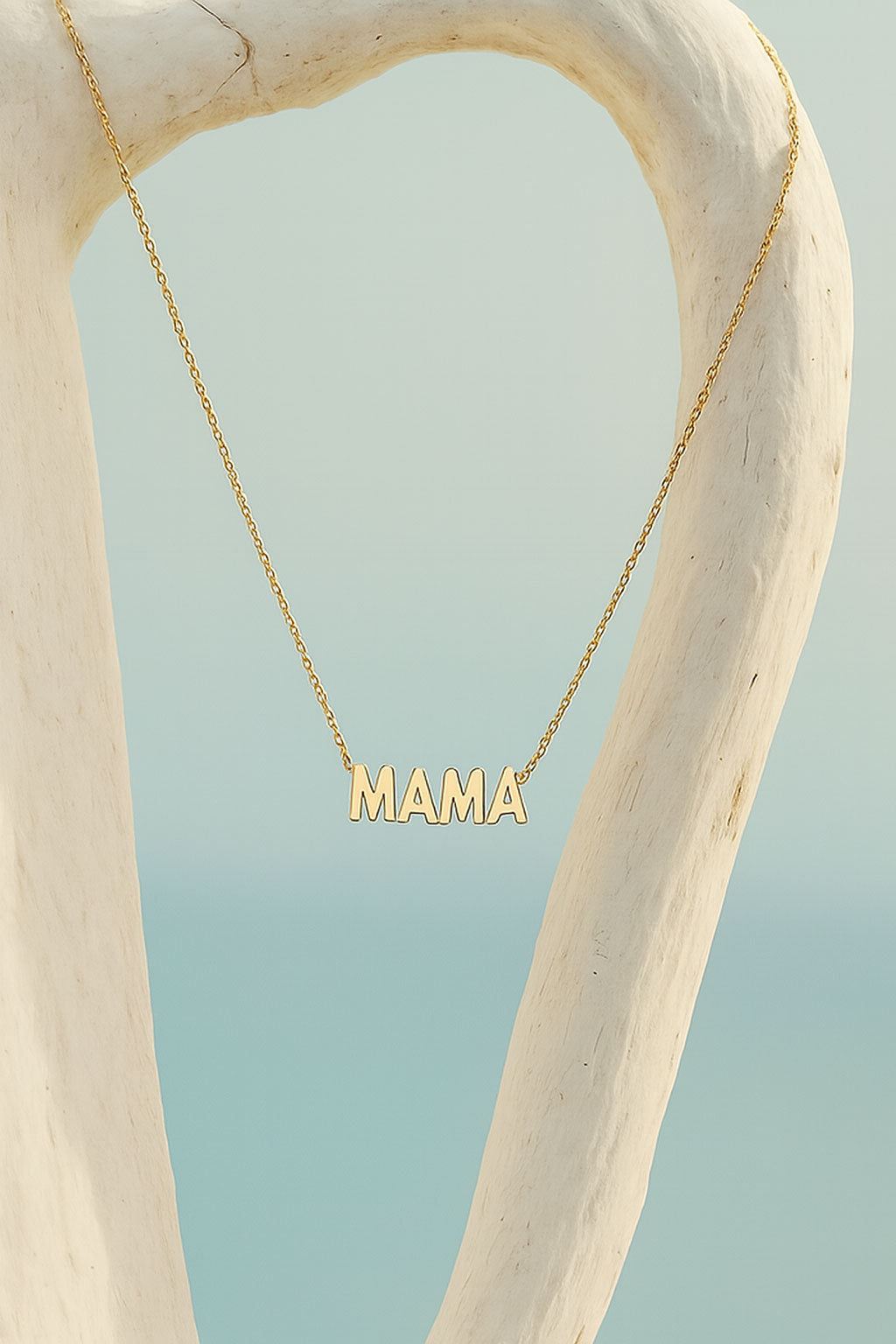Gold necklace with 'MAMA' pendant.