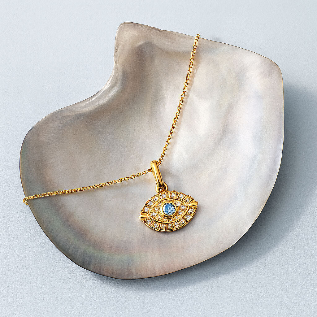 Gold necklace with an eye-shaped pendant on a shell