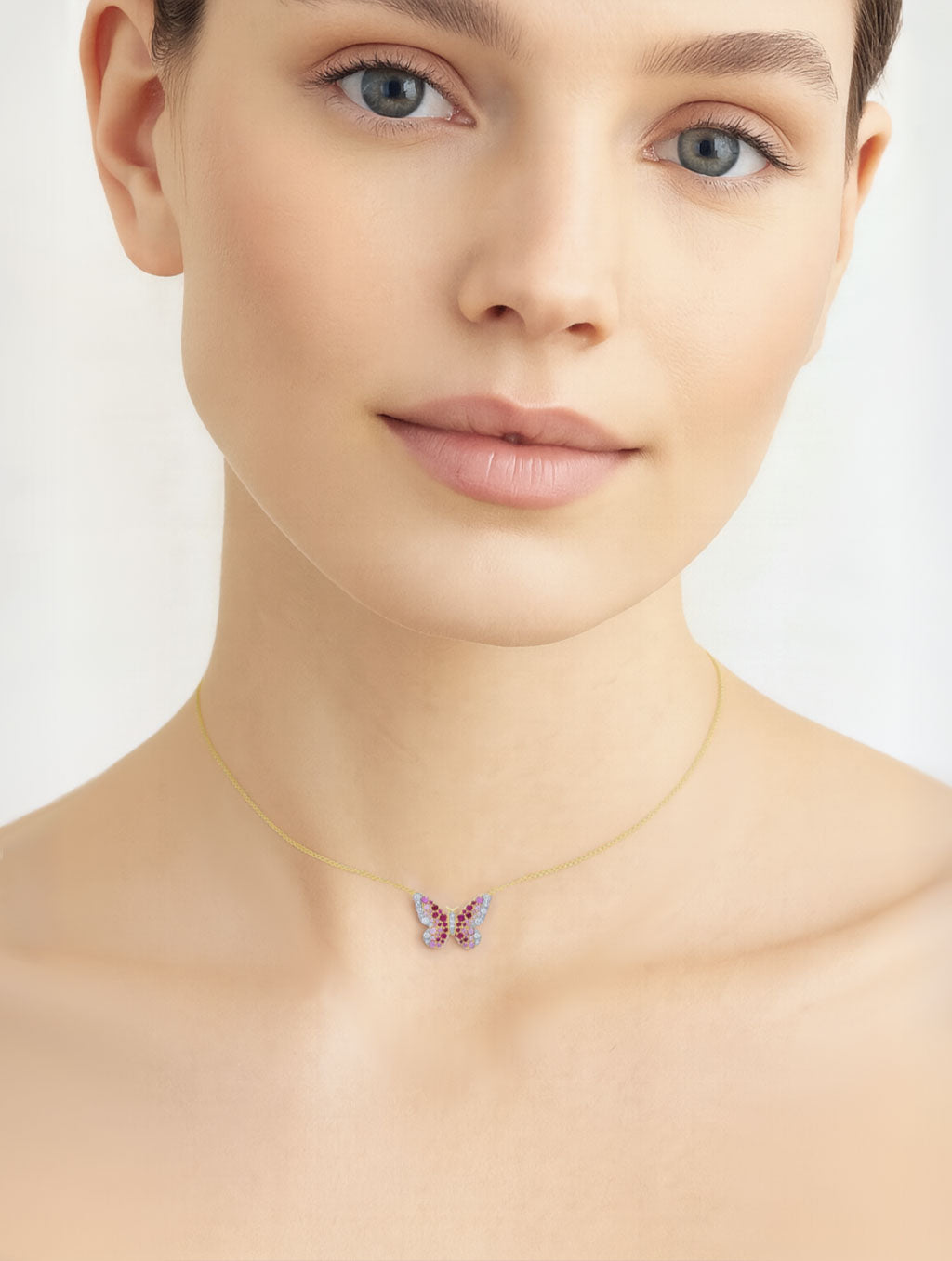 Woman wearing a delicate gold necklace with a butterfly pendant